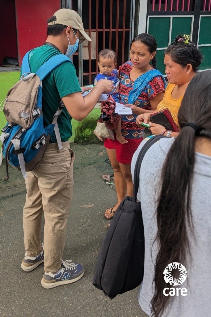 CARE project staff hands out information flyers to city residents about how to prevent dengue and leptospirosis.